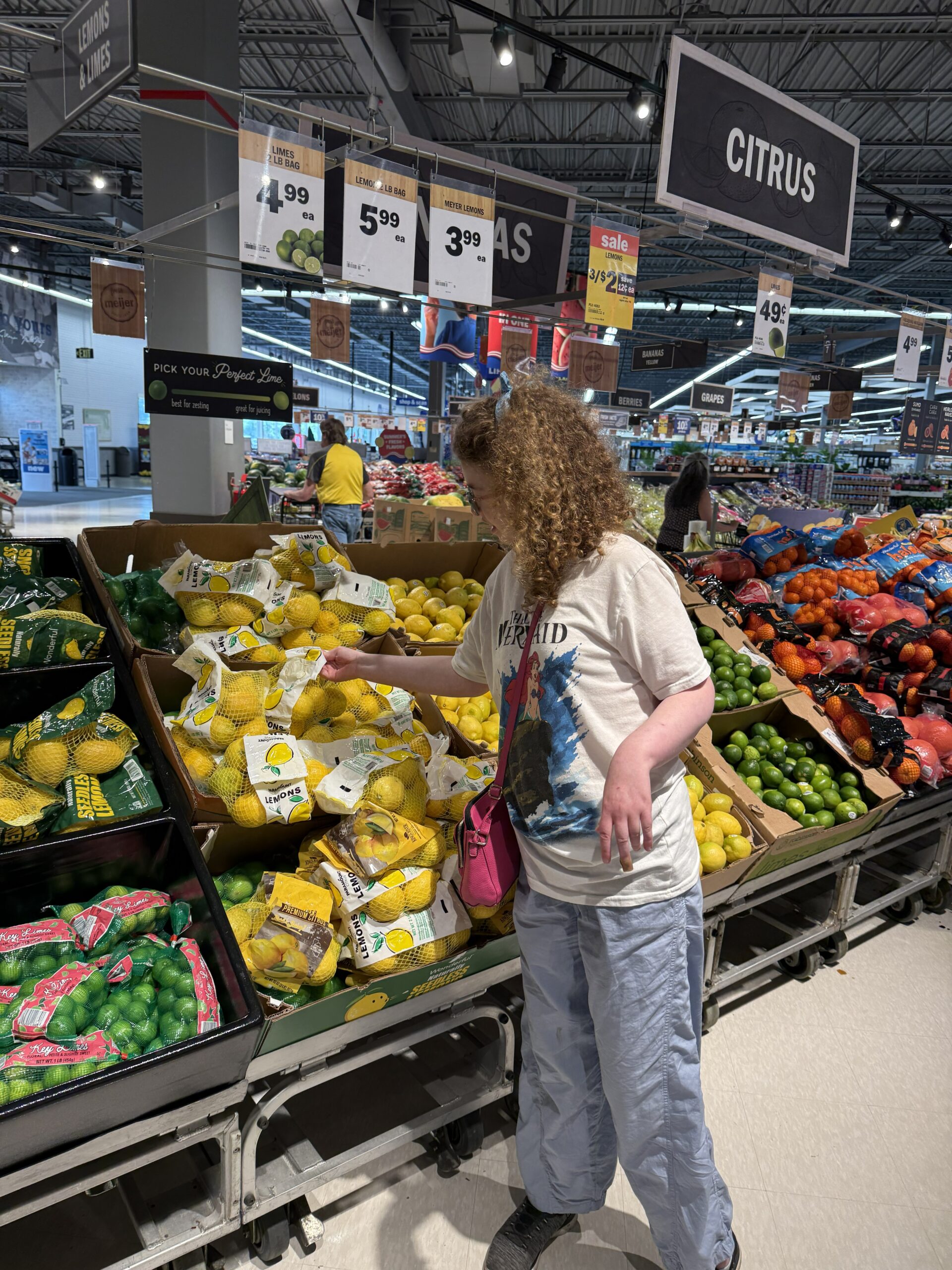 AACORN participant selecting bags of lemons in a grocery store.