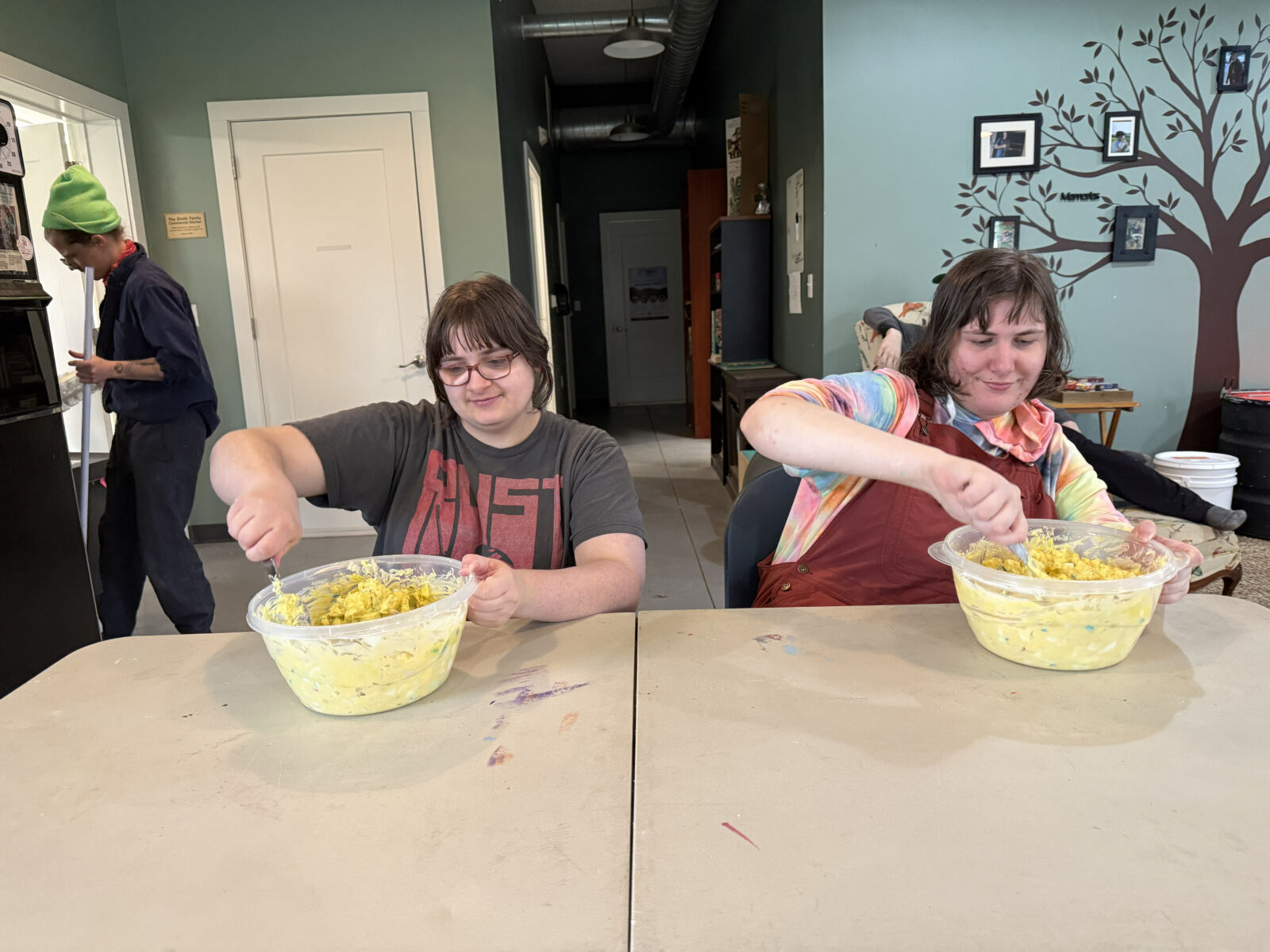 Two participants mixing ingredients in bowls.
