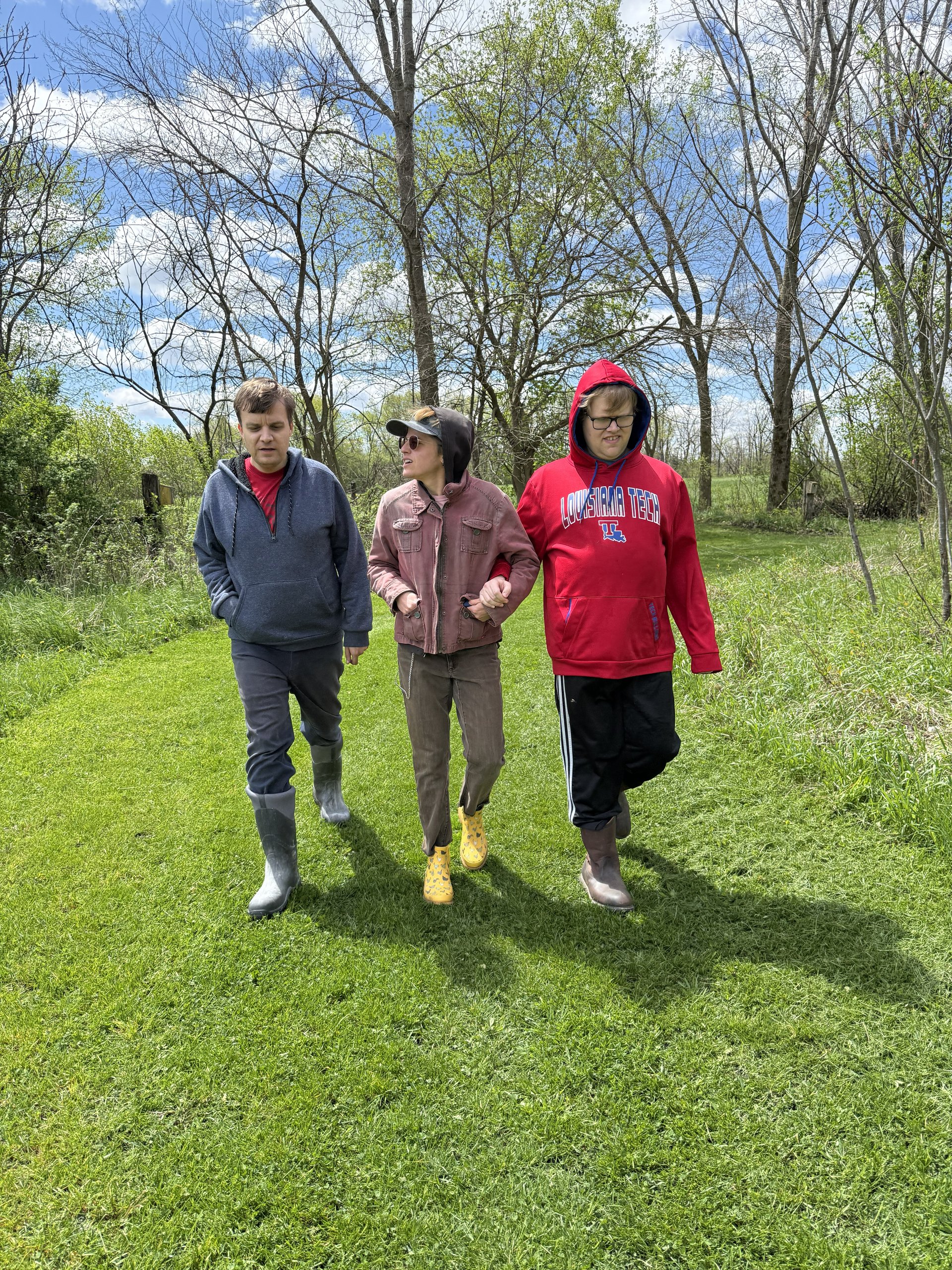 Participants and staff walking along a grassy trail.