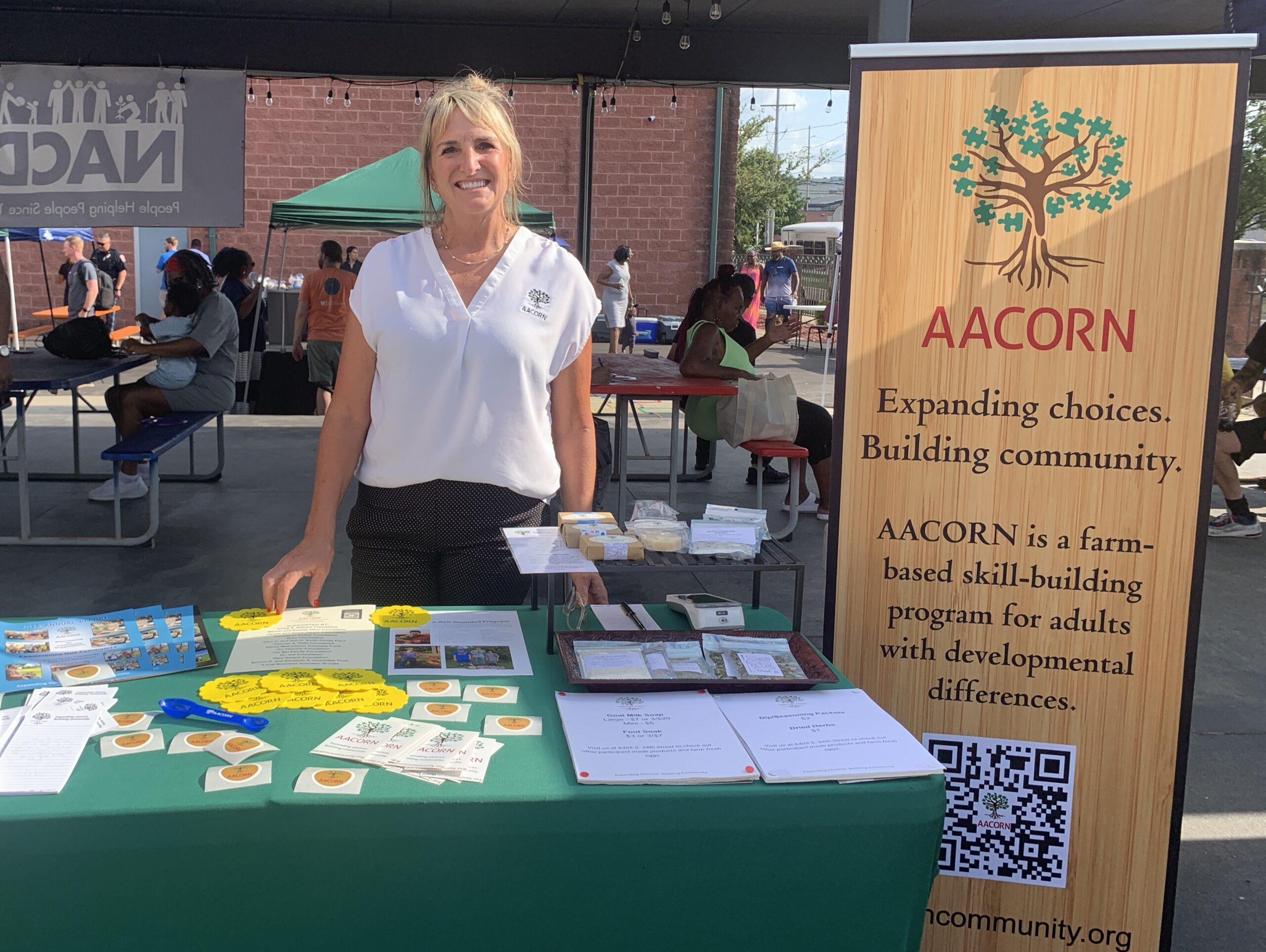 Director of Communications and Community Engagement standing at a community exhibit.