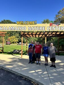 Group standing under Kalamazoo Nature Center entry sign